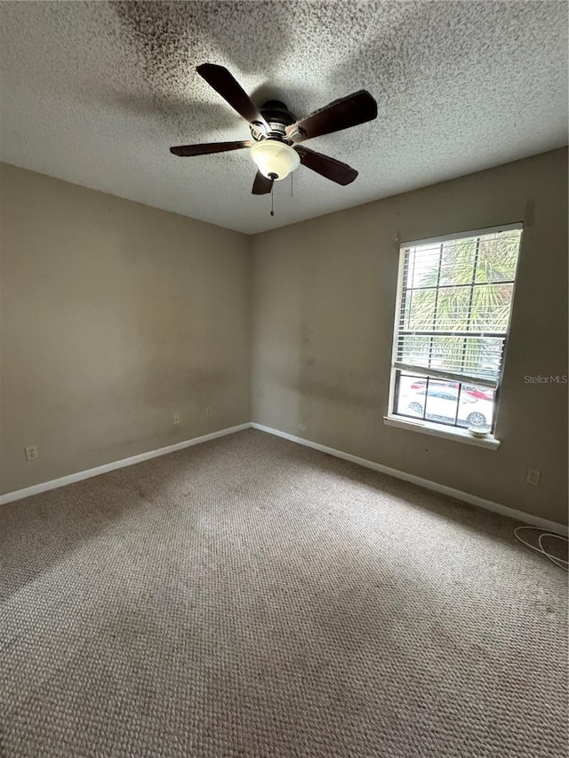 carpeted spare room with ceiling fan and a textured ceiling