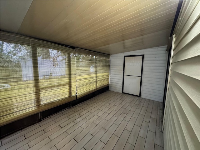 unfurnished sunroom featuring vaulted ceiling