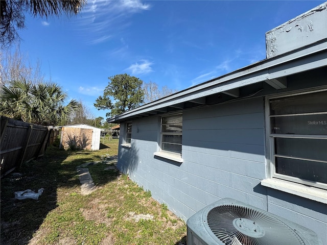 view of side of property with cooling unit and a shed