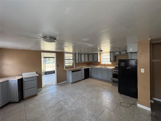 kitchen with gray cabinetry, sink, a wealth of natural light, and black appliances