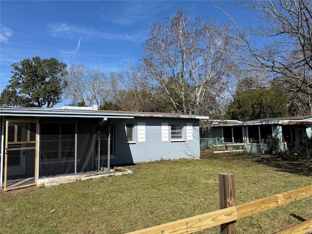 back of house featuring a yard and a sunroom