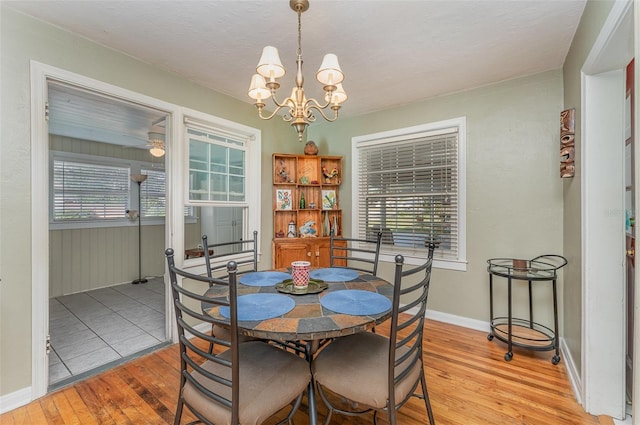 dining area featuring hardwood / wood-style flooring, a wealth of natural light, and a notable chandelier