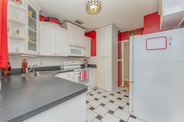 kitchen with tasteful backsplash, sink, white cabinets, and white appliances