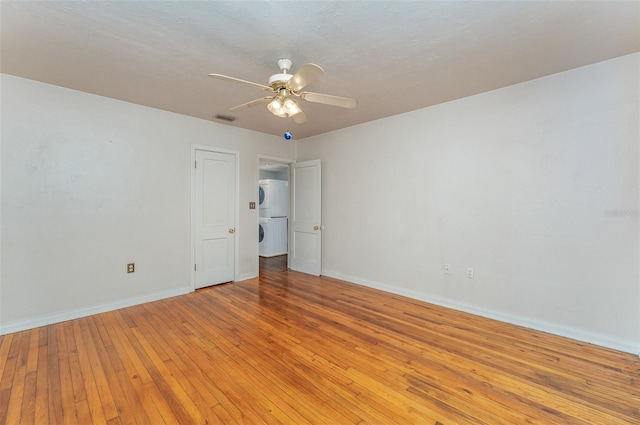 empty room featuring a textured ceiling, light wood-type flooring, and ceiling fan