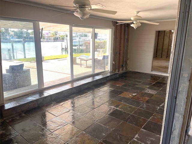 empty room with ceiling fan and a water view