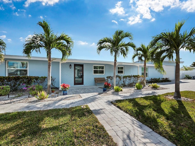 single story home featuring a garage and a front yard