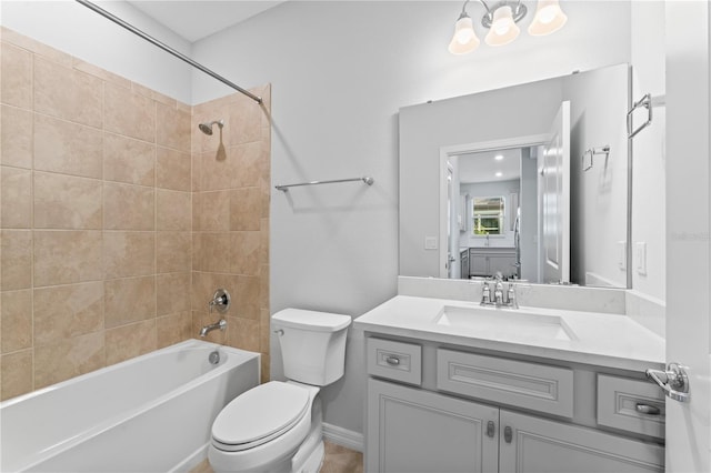 full bathroom featuring vanity, tiled shower / bath combo, and toilet