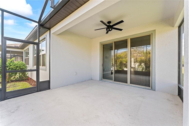 unfurnished sunroom featuring beamed ceiling and ceiling fan