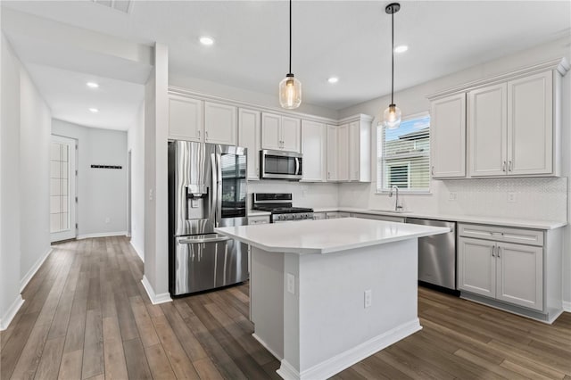 kitchen with pendant lighting, a center island, white cabinets, dark hardwood / wood-style floors, and stainless steel appliances