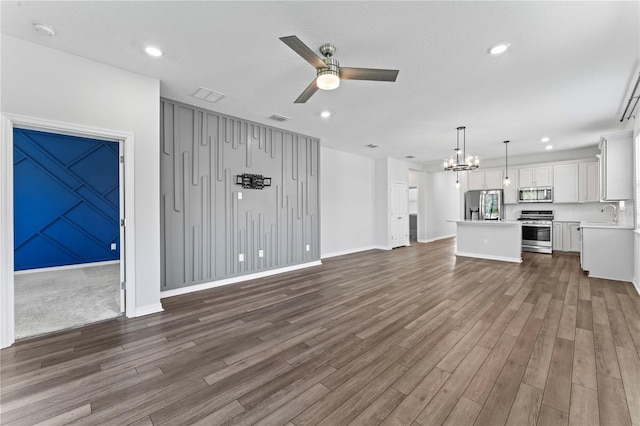 unfurnished living room featuring ceiling fan, dark wood-type flooring, and sink