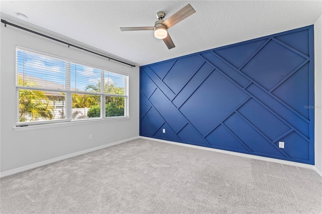 carpeted empty room with ceiling fan and a textured ceiling