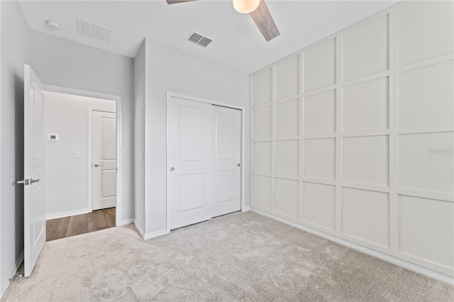 unfurnished bedroom with ceiling fan, a closet, and light colored carpet