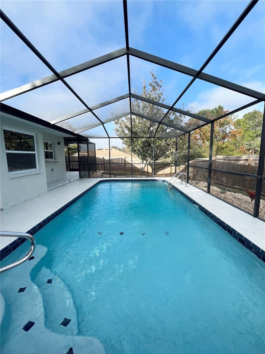 view of swimming pool featuring a lanai and a patio area