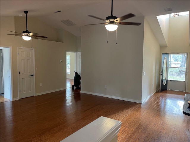 unfurnished living room with hardwood / wood-style flooring, high vaulted ceiling, and ceiling fan