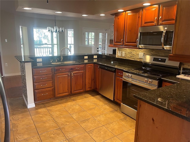 kitchen featuring an inviting chandelier, sink, light tile patterned floors, appliances with stainless steel finishes, and kitchen peninsula