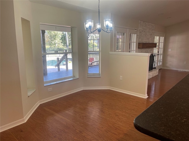 unfurnished dining area featuring dark hardwood / wood-style floors and a notable chandelier