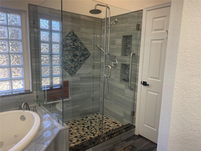 bathroom with a healthy amount of sunlight and shower with separate bathtub