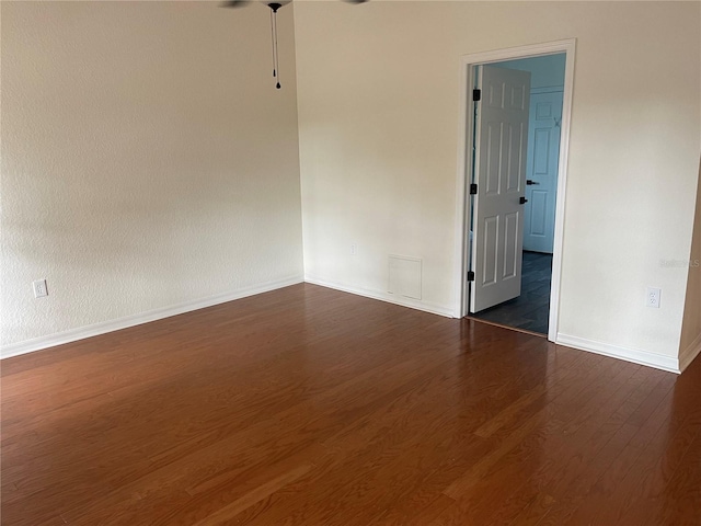 empty room with dark hardwood / wood-style flooring