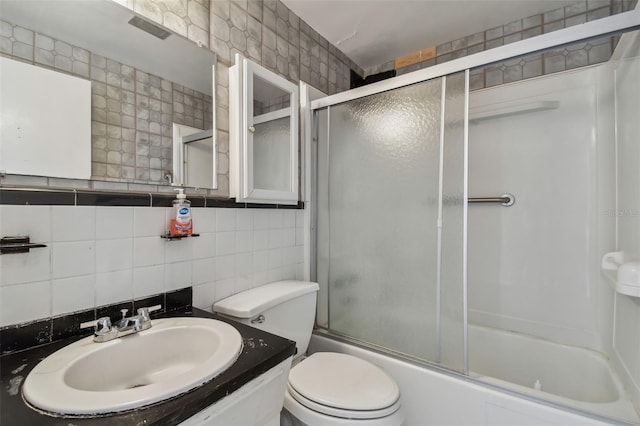 full bathroom featuring combined bath / shower with glass door, tasteful backsplash, sink, tile walls, and toilet