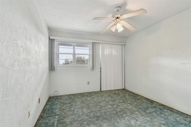 empty room with dark carpet and ceiling fan