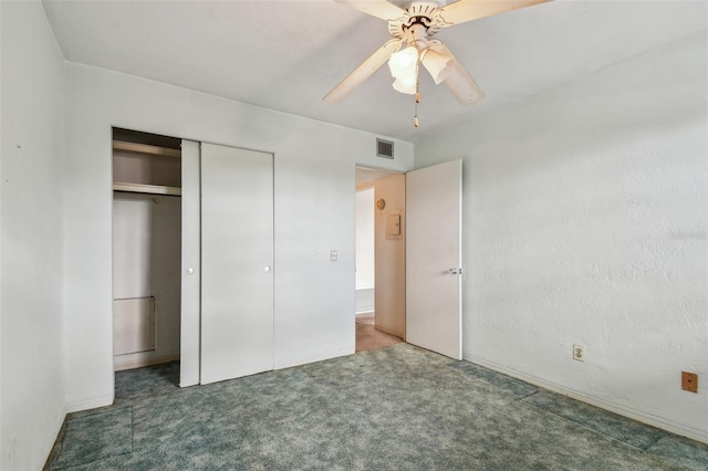 unfurnished bedroom with a closet, dark carpet, and ceiling fan