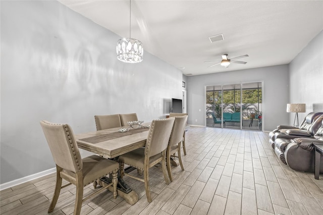 dining area featuring light hardwood / wood-style flooring and ceiling fan with notable chandelier