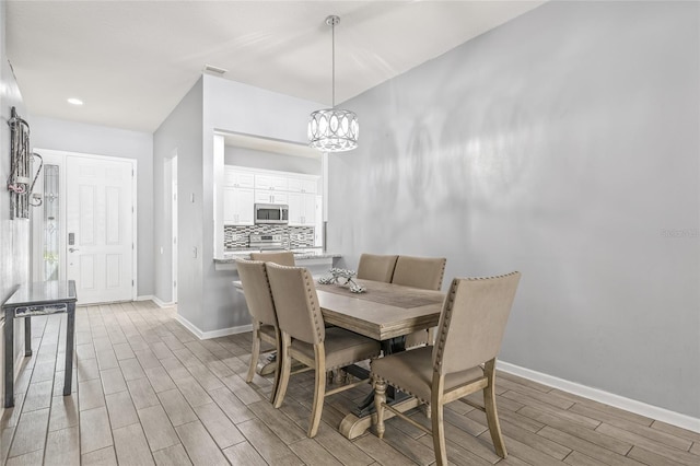 dining space with a notable chandelier and light hardwood / wood-style flooring