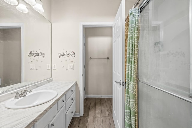 bathroom with a shower, vanity, and wood-type flooring