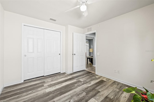 unfurnished bedroom featuring ceiling fan, wood-type flooring, and a closet