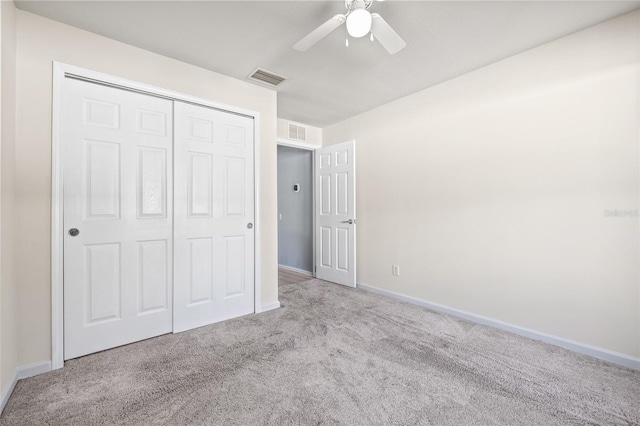 unfurnished bedroom featuring ceiling fan, light colored carpet, and a closet