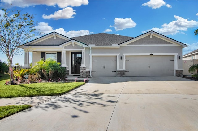 craftsman inspired home with a garage and a front lawn