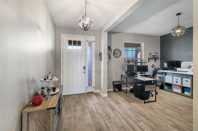 foyer entrance with a chandelier and light wood-type flooring