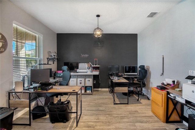 home office with light hardwood / wood-style flooring