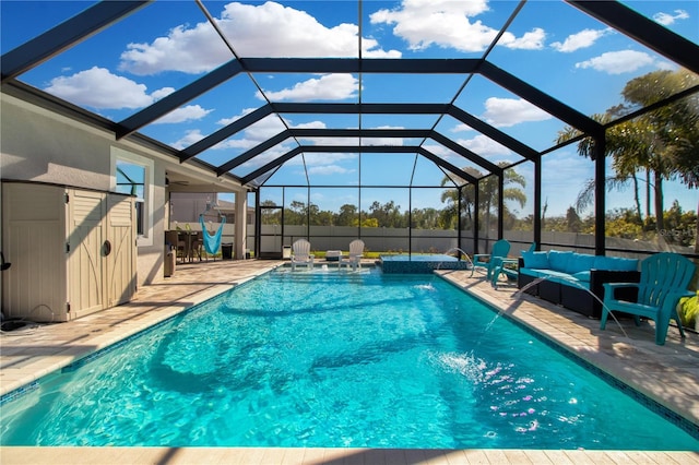 view of pool featuring an in ground hot tub, outdoor lounge area, pool water feature, glass enclosure, and a patio area