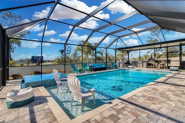 view of pool with pool water feature, a patio area, and a lanai