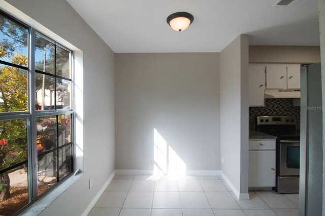 unfurnished dining area featuring light tile patterned floors