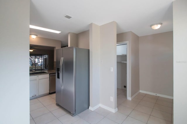 kitchen with white cabinetry, sink, light tile patterned floors, and appliances with stainless steel finishes