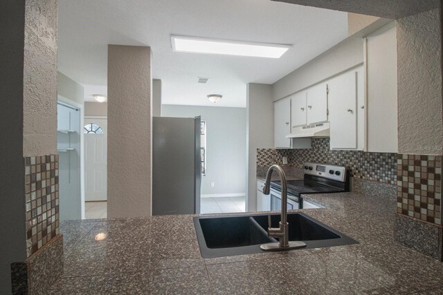 kitchen with appliances with stainless steel finishes, backsplash, white cabinetry, and sink