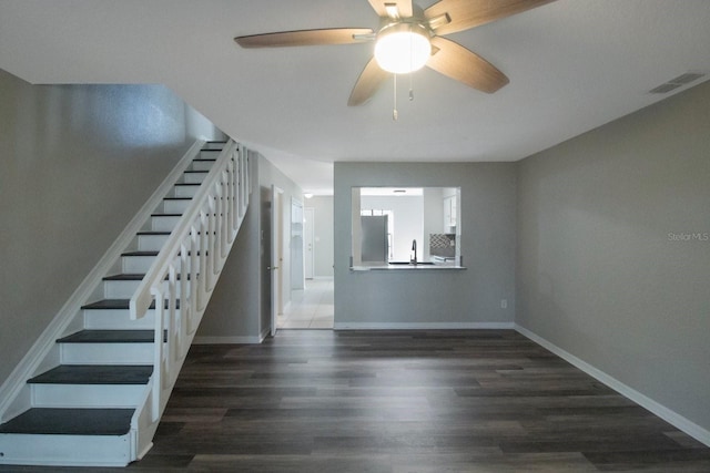 staircase featuring ceiling fan, hardwood / wood-style floors, and sink