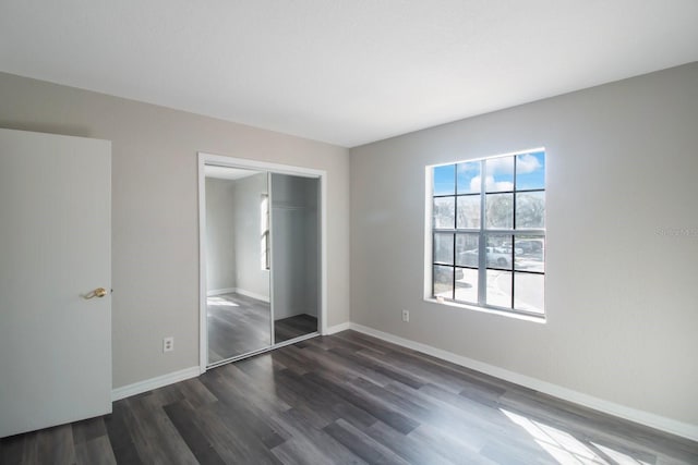 unfurnished bedroom featuring dark hardwood / wood-style flooring and a closet