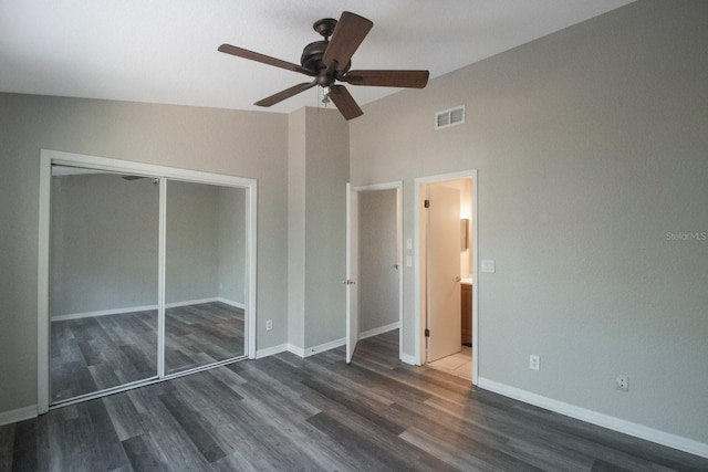 unfurnished bedroom featuring dark hardwood / wood-style floors, a closet, lofted ceiling, and ceiling fan