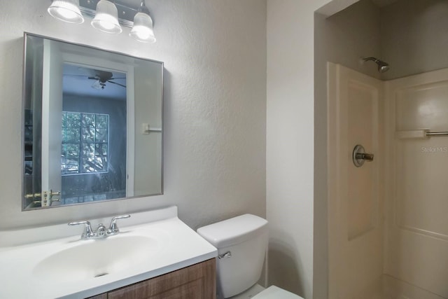 bathroom featuring a shower, vanity, and toilet