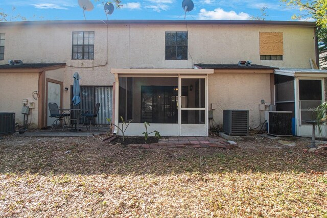 rear view of property with central AC, a patio area, and a sunroom