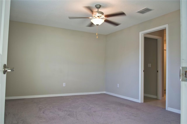 spare room featuring light carpet and ceiling fan