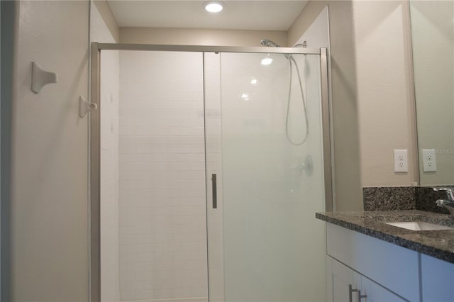 bathroom featuring vanity and a shower with door