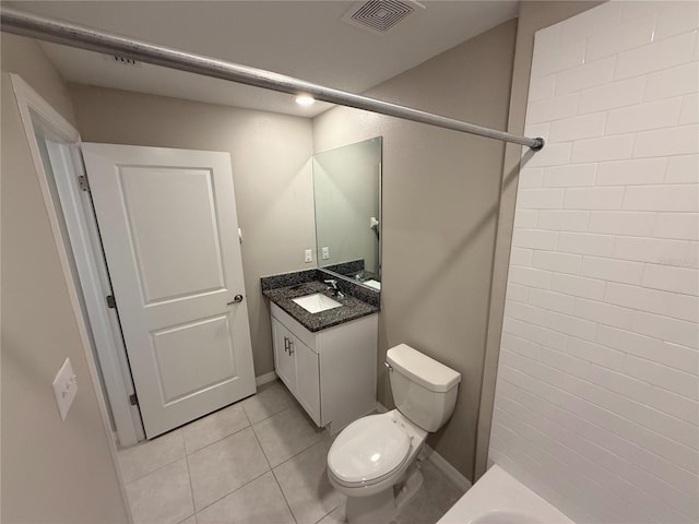 bathroom with toilet, a tile shower, vanity, and tile patterned floors