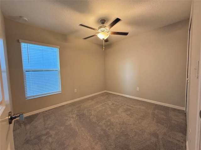 carpeted spare room featuring ceiling fan and a textured ceiling