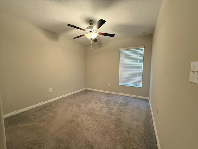 carpeted spare room featuring ceiling fan and a textured ceiling