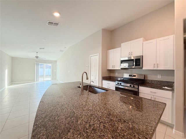 kitchen featuring white cabinets, sink, stainless steel appliances, and vaulted ceiling