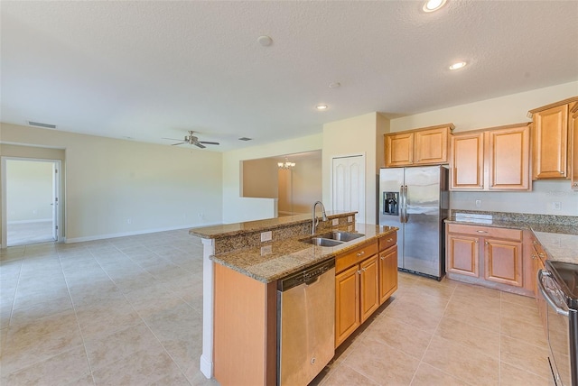 kitchen with ceiling fan, sink, a center island with sink, light tile patterned floors, and appliances with stainless steel finishes